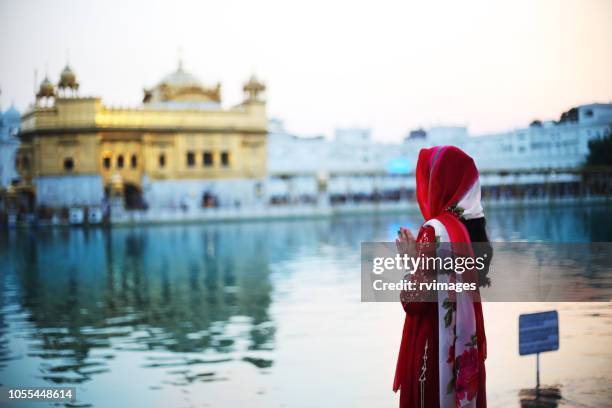 young woman praying to god in golden temple, india - amritsar india stock pictures, royalty-free photos & images