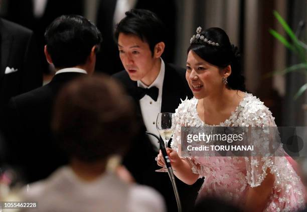 Japan's former princess Ayako Moriya and her husband Kei Moriya toast with Crown Prince Naruhito at their wedding banquet in Tokyo on October 30,...