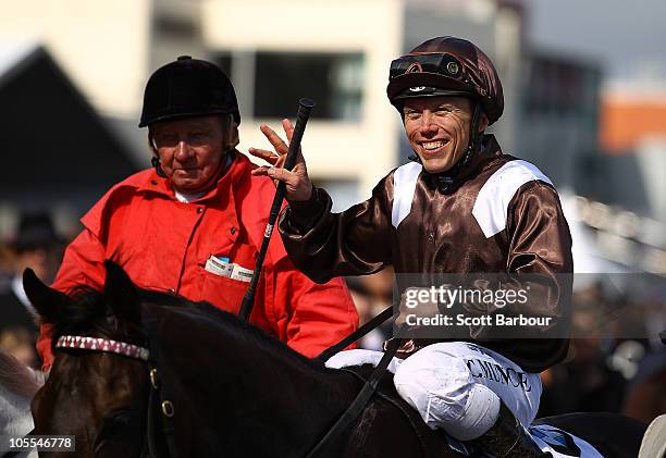 Jockey Chris Munce gestures after riding Descarado to win race 8 the BMW Caulfield Cup during Caulfield Cup Day at Caulfield Racecourse on October...