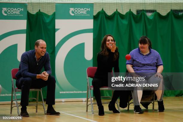 Britain's Prince William, Duke of Cambridge, looks on as Britain's Catherine, Duchess of Cambridge, plays boccia with a participant as they join a...