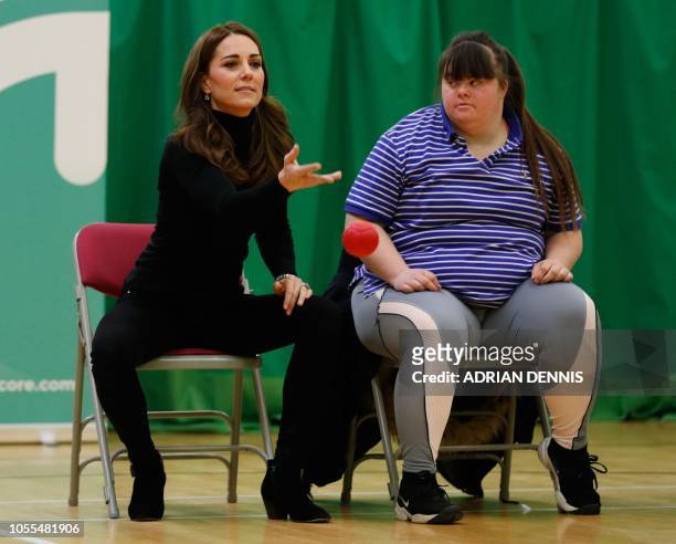Britain's Catherine, Duchess of Cambridge, plays boccia with a participant as she joins a session during a visit to learn about the Coach Core Essex...