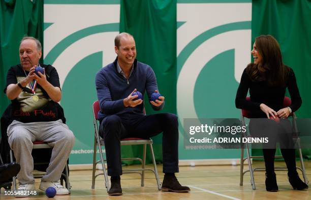 Britain's Catherine, Duchess of Cambridge, laughs with Britain's Prince William, Duke of Cambridge, as they play boccia with a participant as they...