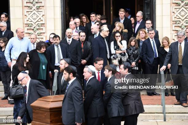 Mourners gather as a casket is carried outside the Rodef Shalom Congregation where the funeral for Tree of Life Congregation mass shooting victims...