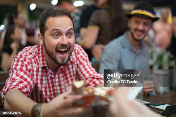 dronken man delen krakeling op oktoberfest - oktoberfest stockfoto's en -beelden