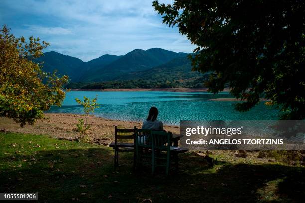 This photograph taken on October 30 shows a woman sitting beside the artificial lake of Ladon, in the northwestern area of Arcadia in Greece.