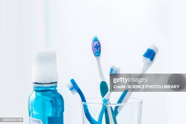toothbrushes in glass with mouthwash - mundspülung stock-fotos und bilder