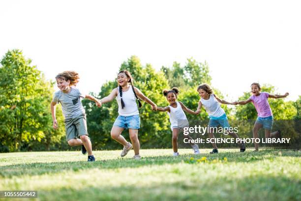 children holding hands and running - acchiappino foto e immagini stock