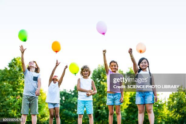 children standing with balloons - releasing balloon stock pictures, royalty-free photos & images