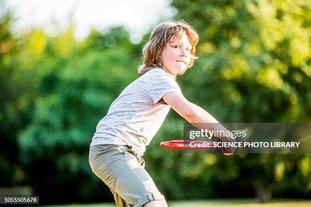 boy throwing flying disc - frisbee stock pictures, royalty-free photos & images