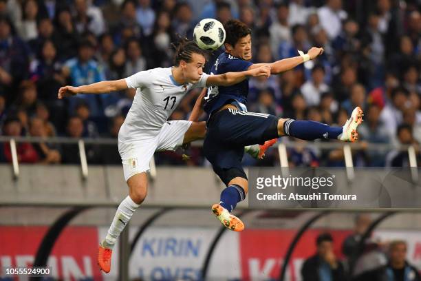 Hiroki Sakai of Japan and Martin Caceres of Uruguay compete for the ball during the international friendly match between Japan and Uruguay at Saitama...