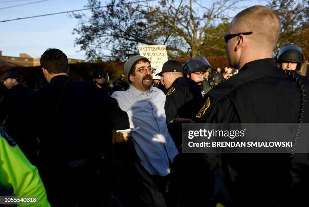 Riot police remove a protester near the Tree of Life Congregation on October 30, 2018 in Pittsburgh, Pennsylvania. - Scores of protesters took to the...