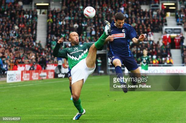 Mikael Silvestre of Bremen battles for the ball with Daniel Caligiuri of Freiburg during the Bundesliga match between SV Werder Bremen and SC...