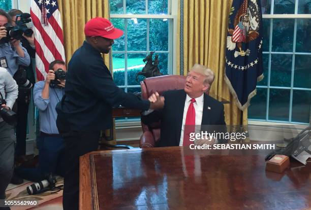 In this file photo US President Donald Trump meets with rapper Kanye West in the Oval Office of the White House in Washington, DC, October 11, 2018....