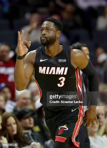 Dwyane Wade of the Miami Heat reacts after making a basket against the Charlotte Hornets during their game at Spectrum Center on October 30, 2018 in...