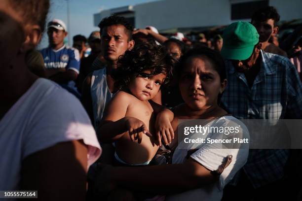Members of the Central American caravan react while listening to a meeting and spiritual service at an evening camp on October 30, 2018 in Juchitan,...