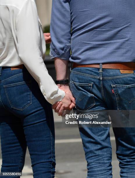 Couple hold hands as they cross an intersection in San Francisco, California.