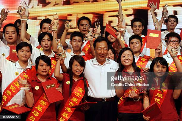 Terry Gou, Chairman of Foxconn Technology Group, poses with awarded grass roots employees of the year at Foxconn's industrial complex in Longhua...