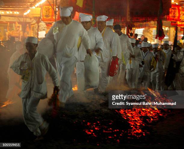 Members of the Malaysian ethnic Chinese community walk barefoot on burning coals as they perform firewalking on the last day of the Nine Emperor Gods...