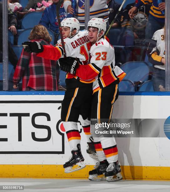 Johnny Gaudreau of the Calgary Flames celebrates his game winning overtime goal against the Buffalo Sabres with Sean Monahan during an NHL game on...