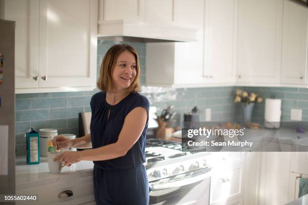 mom in kitchen making a cup of coffee - morning coffee stock pictures, royalty-free photos & images