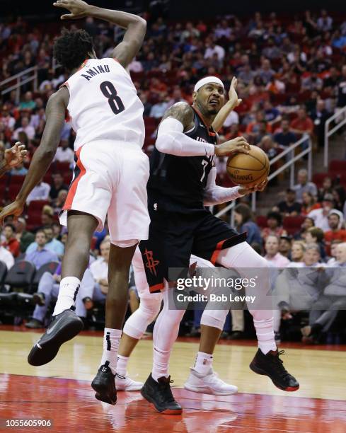 Carmelo Anthony of the Houston Rockets shoots between Al-Farouq Aminu of the Portland Trail Blazers and Evan Turner during the fourth quarter at...