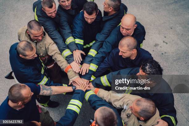 vigili del fuoco con le mani accatastate - rescue worker foto e immagini stock