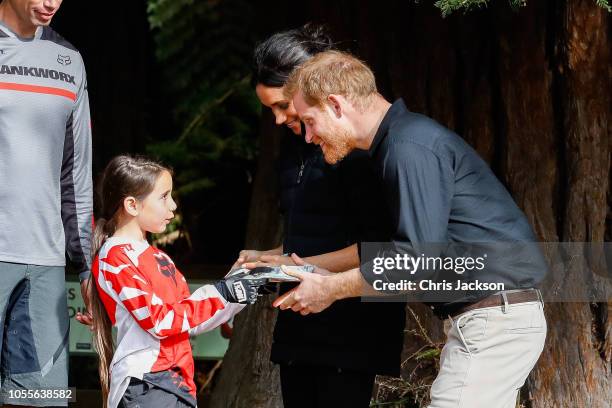 Prince Harry, Duke of Sussex and Meghan, Duchess of Sussex being given a gift from young cyclist Redwoods Treewalk Rotorua on October 31, 2018 in...