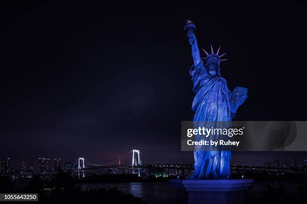 liberty statue replica with the tokyo skyline at the background by night - statue of liberty sunset stock pictures, royalty-free photos & images