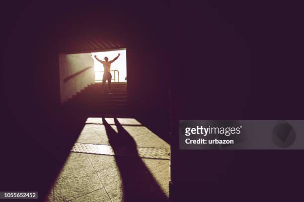 muskulöser mann auf einer treppe - siegerpose stock-fotos und bilder