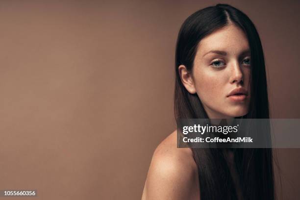 retrato de mujer sonriente delante de pared negro - cabello-castaño fotografías e imágenes de stock