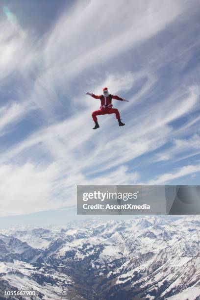 skydiver dressed as santa claus falls towards the earth - aerial stunts flying stock pictures, royalty-free photos & images