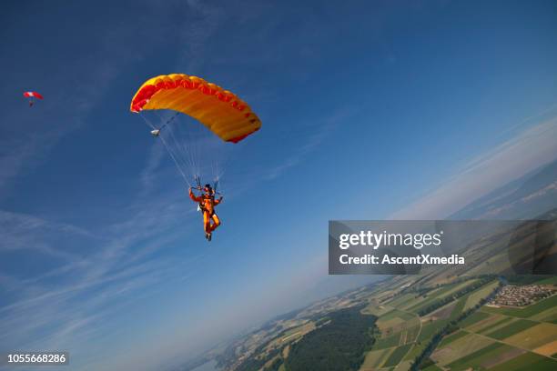 paraglider glides towards the earth - parachute stock pictures, royalty-free photos & images