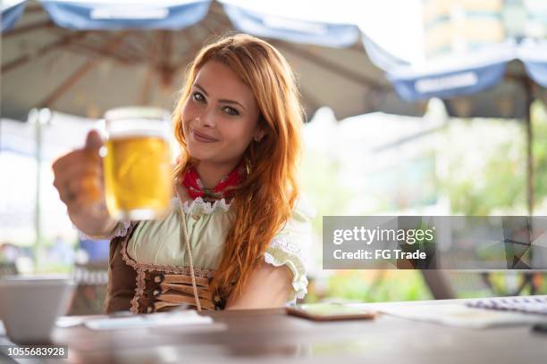beautiful woman showing beer at pub - menina fantasia bonita imagens e fotografias de stock