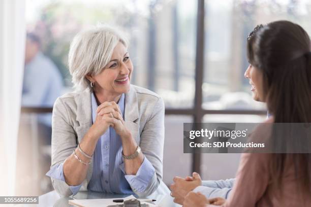 cheerful financial advisor meets with clients - old woman young man stock pictures, royalty-free photos & images