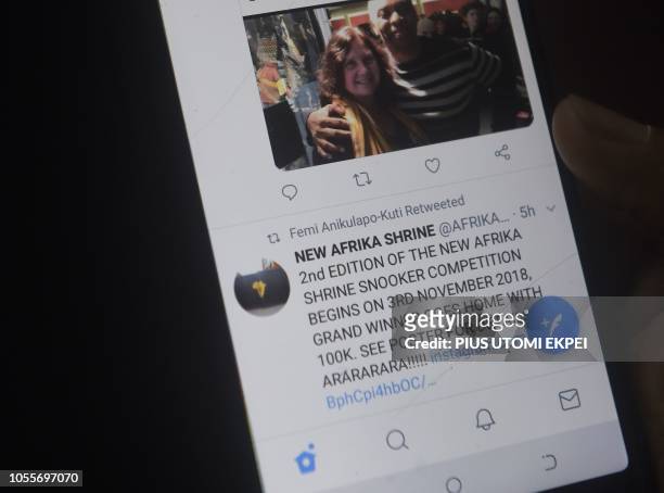 Lady tries to tweet with a smartphone in Lagos, on October 29, 2018. - Nigeria has an unenviable reputation around the world for corruption and is...