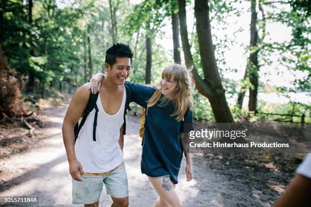 couple walking together in afternoon sun - nature walk stockfoto's en -beelden