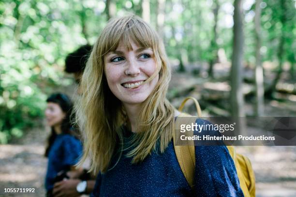 young woman on way to lake with friends - glücklichsein stock-fotos und bilder
