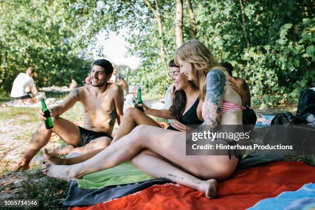 friends hanging out at lake together - red swimwear stock pictures, royalty-free photos & images