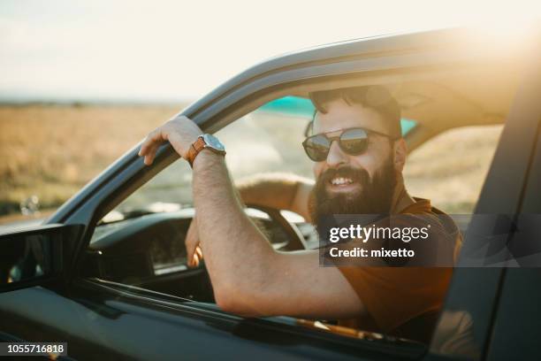 junger mann mit dem auto anreisen - auto mann stock-fotos und bilder