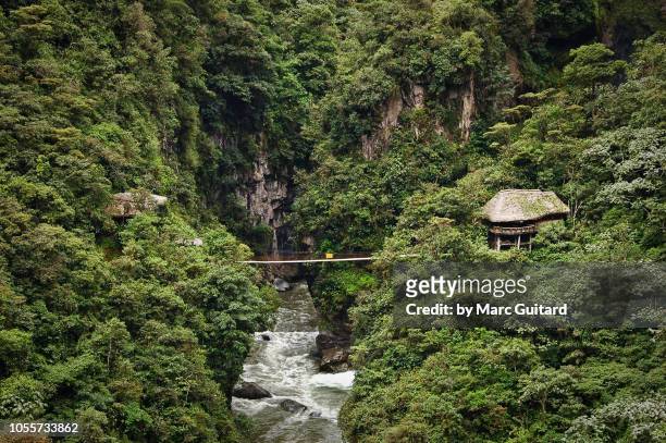 jungle hut and bridge over roaring river, baños, ecuador - ecuador fotografías e imágenes de stock