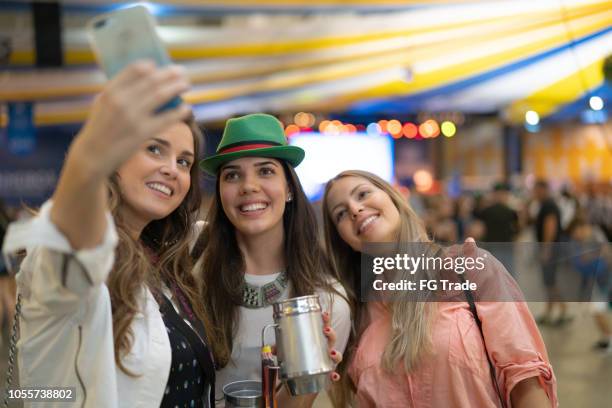 teenager girls taking a selfie at beer fest in blumenau, santa catarina, brazil - oktoberfest party stock pictures, royalty-free photos & images