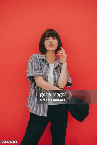 portrait of real woman on red background - asian fashion model stock pictures, royalty-free photos & images