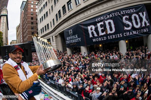 Mookie Betts of the Boston Red Sox holds the World Series trophy as he rides on a duck boat during the 2018 World Series rolling rally parade on...