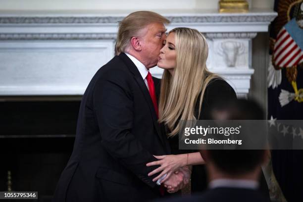 President Donald Trump, left, kisses Ivanka Trump, assistant to President Trump, during the "Our Pledge to America's Workers" event in the State...