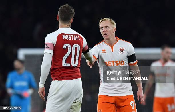 Blackpool's English striker Mark Cullen shakes hands with Arsenal's German defender Shkodran Mustafi following the English League Cup football match...
