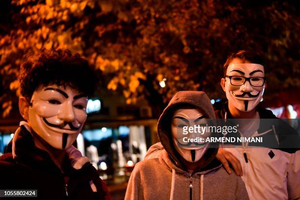 Youths wearing Guy Fawkes masks pose in the street during Halloween celebrations in Pristina, on October 31, 2018.