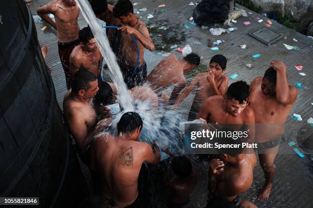 Members of the Central American caravan bathe at dusk while in a camp on October 31, 2018 in Juchitan, de Zaragoza, Mexico. The group of migrants,...