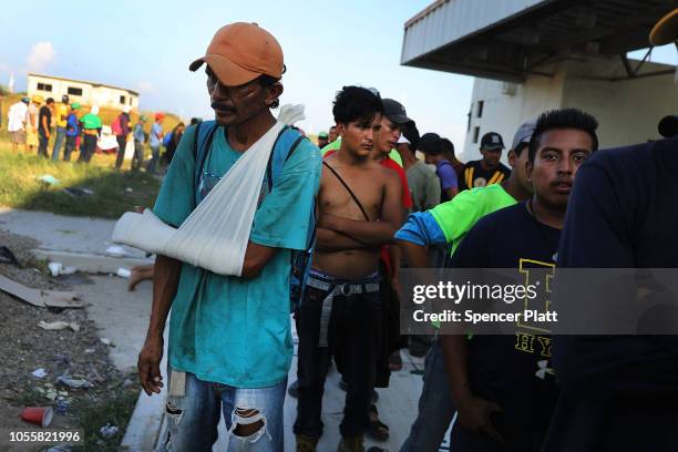 Members of the Central American caravan wait in line for food and other items while in a camp on October 31, 2018 in Juchitan, de Zaragoza, Mexico....