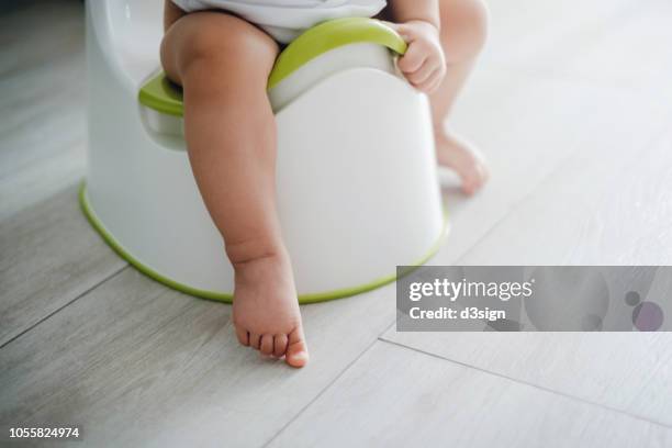 close up of a toddler sitting on a potty chair on potty training - baby pee stock pictures, royalty-free photos & images
