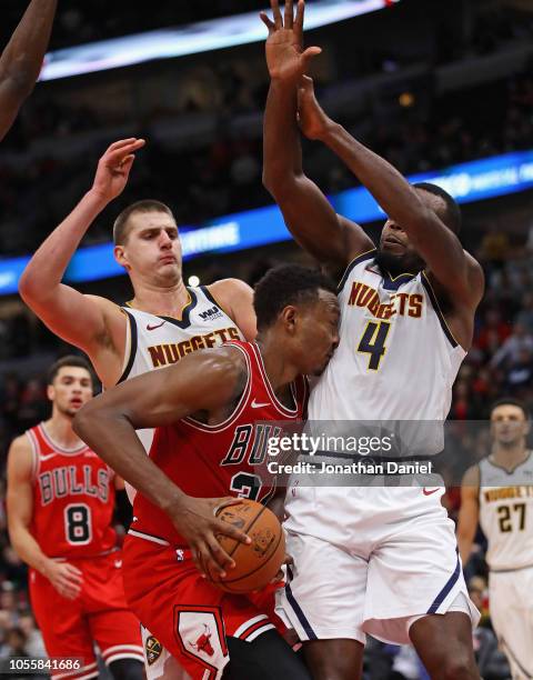 Wendell Carter Jr. #34 of the Chicago Bulls runs into Paul Millsap of the Denver Nuggets as Nikola Jokic also defends at the United Center on October...